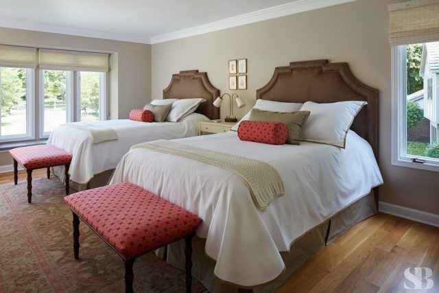 guest bedroom with two queen beds with white sheets and pink benches