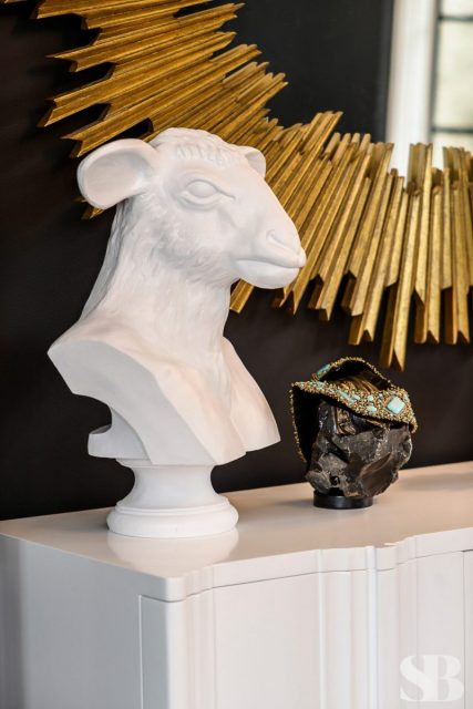 close up of white lamp head statue and gold mirror