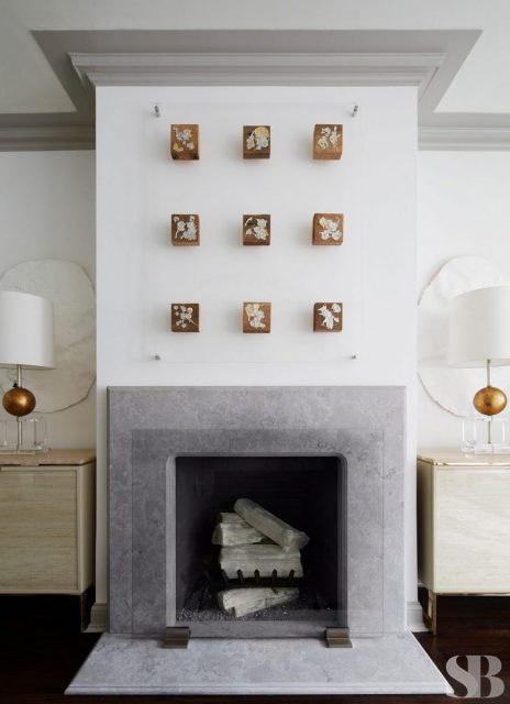 stone fireplace with nine art boxes hanging above