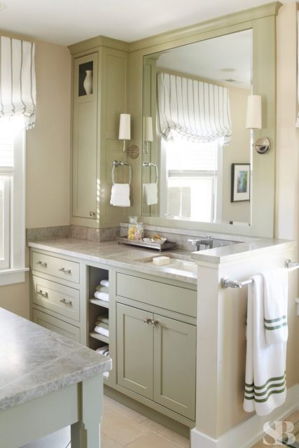 master bathroom with large v anity mirror and light green cabinets