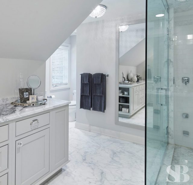 master bathroom with glass shower and white cabinets