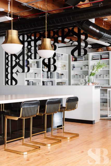 office kitchen with barstools and logo wall